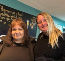 Mother and daughter standing side by side, smiling